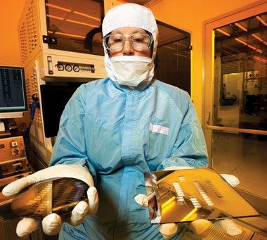 A researcher in the clean room holds wafers on which Livermore Flexible Probes electronics have been manufactured.