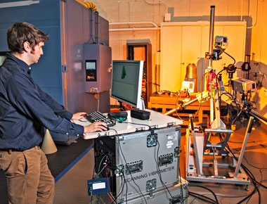 An engineer prepares for a laser vibrometer to measure noncontact vibration of a W80-1 test component.