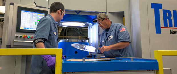 Machinists examine a steel sheet before pressing it into a test part with a new hydroform, the key tool for building experimental parts for the W80-4 LEP.