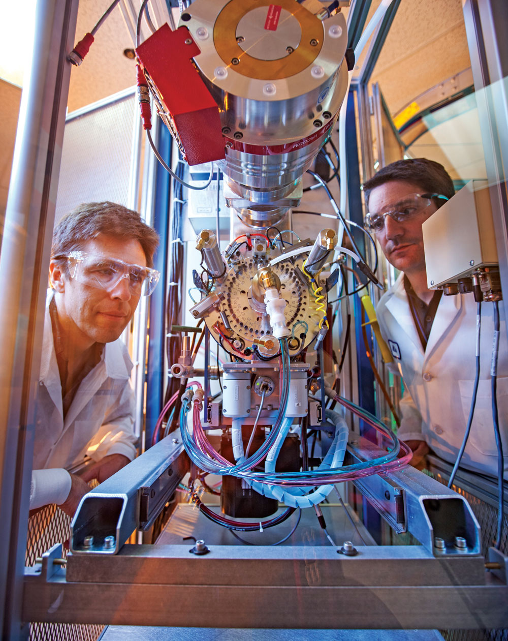 Two scientists peer into an accelerated mass spectrometry unit.