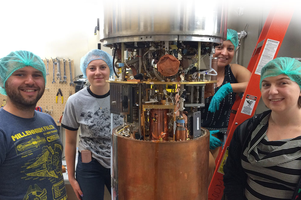 Four scientists standing around the ADMX haloscope.