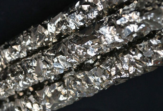 A close-up view of three columns of shiny, craggy zirconium.