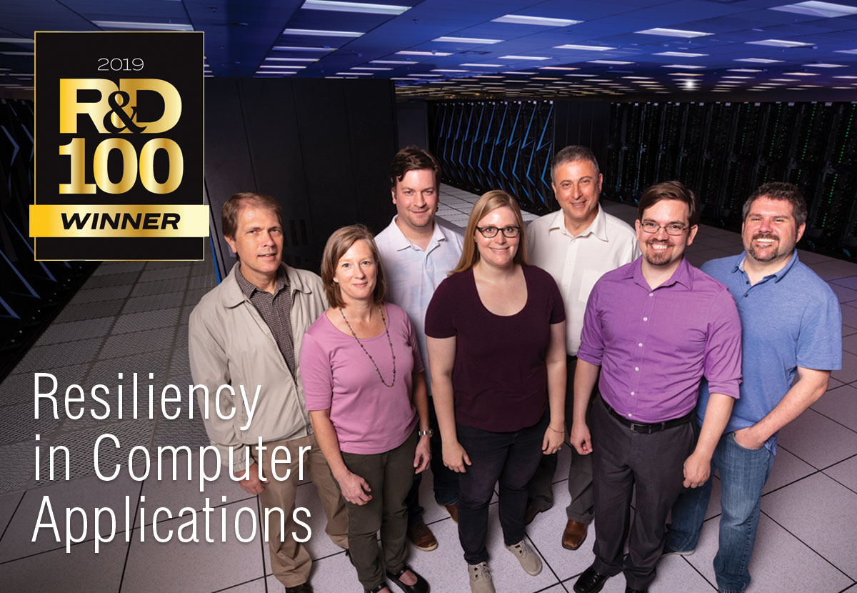 Seven people stand as a group in front of the Sierra supercomputer