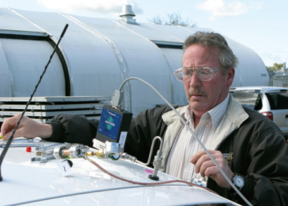 A scientist draws a sample from a vehicle’s hydrogen tank.