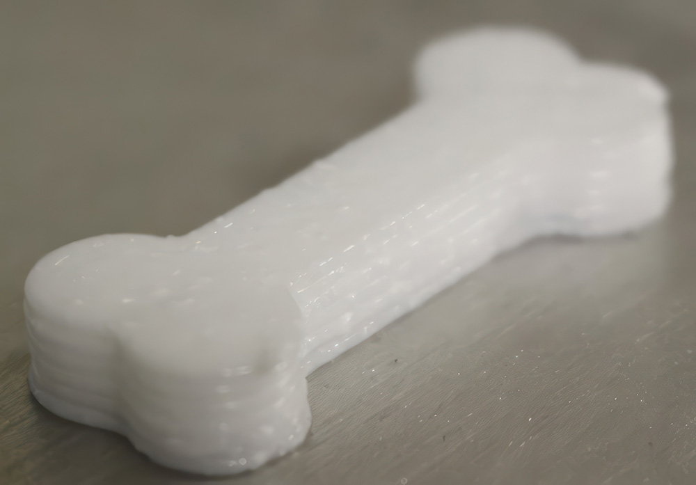 A photo of a  dog-treat sized 3D-printed object that demonstrated the additive manufacturing process for combining the smells of binary explosives.