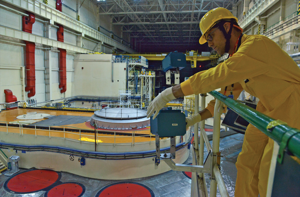 A man uses diagnostic tools in a nuclear reactor.
