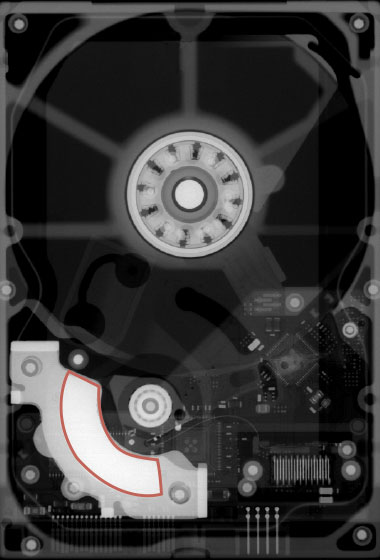 An x-ray radiograph of a hard drive shows the rare earth–containing motor magnet outlined in red. X-ray images such as the one shown here are part of a Livermore-developed method to automate the recovery and recycling of magnets from discarded computer hard drives. 