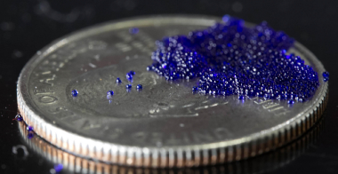 Silicone microcapsules sit on a quarter for scale. The microcapsules contain a sodium carbonate solution that traps carbon dioxide (CO<sub>2</sub>). In an industrial setting, the capsules could be placed in a flue to absorb CO<sub>2</sub> from exhaust gas instead of releasing it into the atmosphere. Once the capsules are saturated, the trapped CO<sub>2</sub> is retrieved in a controlled process. The capsules can then be used again. 