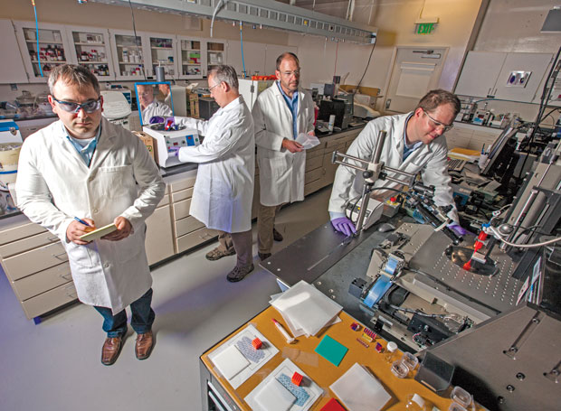 Additive manufacturing (AM) researchers produce polymer parts using Livermore’s direct-ink-writing machine. Shown here (left to right) are Chris Spadaccini, Tom Wilson, Robert Maxwell, and Eric Duoss.  (Photo by George Kitrinos.)