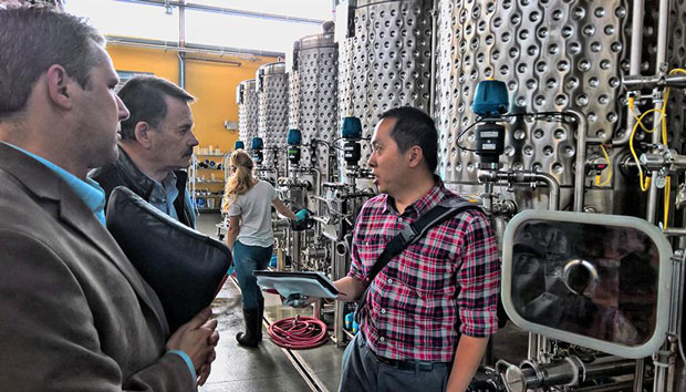 Livermore researcher Congwang Ye (left) visits with professors at the University of California at Davis at their pilot-scale brewery to learn about fermentation tank operations as part of his adaption of a microcapsule technique for trapping carbon dioxide (CO2) to commercial breweries. Ye hit on this application through his participation in Energy I-Corps.   