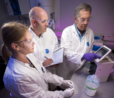 (from left) Livermore’s Kerri Treinen, Richard Essex of the National Institute of Standards and Technology, and Williams review the procedures for dispensing a certified reference material from a master solution. (Photo by Randy Wong.)