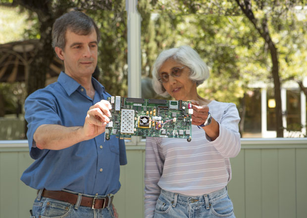 Computer scientists (from left) Scott Lloyd and Maya Gokhale inspect a  memory unit emulator on a circuit board. (Photo by Lanie L. Rivera.)